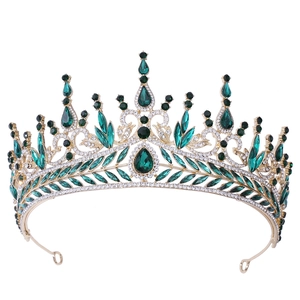 Macro detail of golden bridal crown with emerald green teardrop crystals and rhinestones