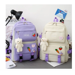 Detail of canvas backpack set featuring large capacity and cute cartoon pins and charms