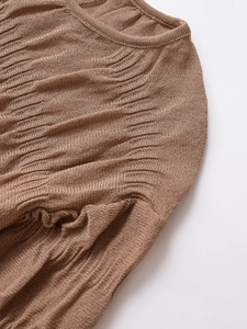 Detail of coffee brown pleated knit blouse showing round neckline and shoulder texture