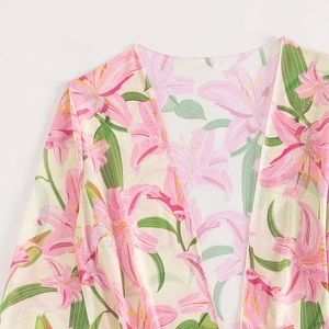 Dettaglio della stampa floreale di giglio rosa su tessuto di chiffon bianco con scollo a V