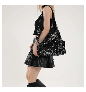 Close-up of sparkling black and silver sequins on a stylish punk-style tote bag texture