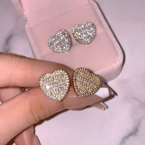 Detailed view of gold and silver heart earrings with sparkling cubic zirconia inlay