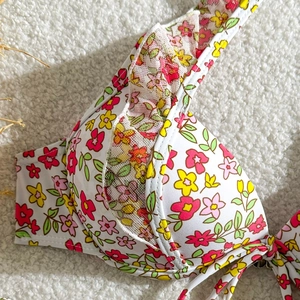 Détail du haut de bikini à imprimé fleuri avec volants en mesh et armatures de soutien