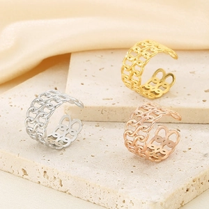 Three hollow chain-link adjustable rings in gold, silver, and rose gold on a stone base