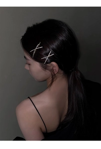 Close-up of sparkling crisscross hair clip with rhinestones worn on hair by a model