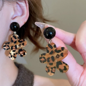 Nahaufnahme von Ohrringen mit Leopardenblumenmuster und schwarzen Kugelsteckern