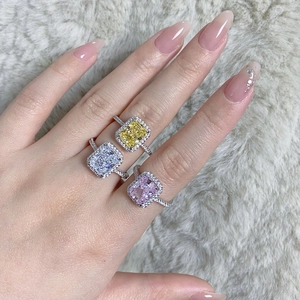 Close-up of radiant cut S925 silver rings with blue, yellow and pink halo gemstones