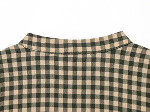 Close-up of black and beige plaid pattern on a long-sleeved shirt with detailed fabric texture