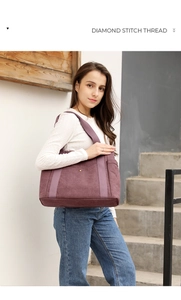 Detailed view of dark maroon canvas tote bag with wide strap and front snap pocket
