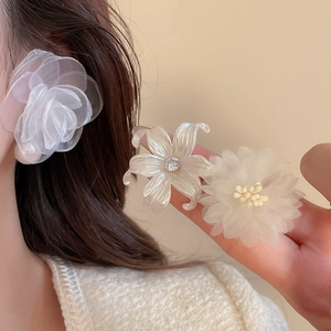 Detailed view of layered organza rose, pearl flower, and daisy earrings with rhinestones