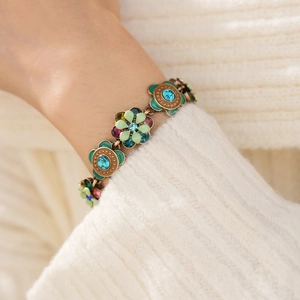 Close-up of vintage floral bracelet with crystals on wrist against knit background