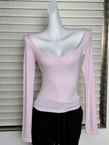 Macro detail of pink long sleeve top showing U-neckline and elastic slimming fit texture