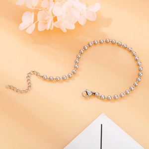 Detalle de pulsera de cuentas plateadas con cierre de langosta y cadena extensible