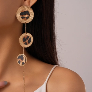 Close-up of elegant gold leopard print drop earrings worn by a model in detail