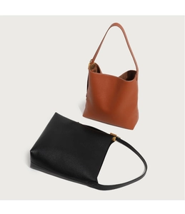 Details minimalistischer Lederbeutel in Schwarz und Braun mit feiner Lychee-Textur
