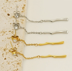 Detailed view of gold and silver bamboo tassel earrings with sparkling zircon studs