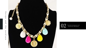 Chunky gold chain necklace with colorful teardrop charms and vintage coin details