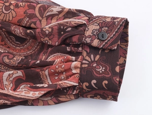 Detailed macro shot of vintage paisley print chiffon cuff with gathered pleats and button
