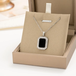 Detail of a square black gemstone necklace with white zircon halo in a gift box