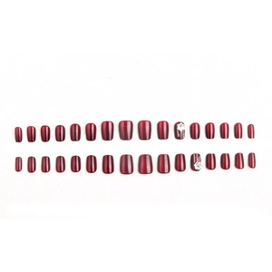 Faux ongles œil de chat rouge cerise avec paillettes et accents floraux en strass