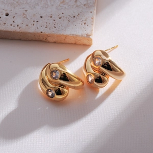 Detailed close-up of gold double water drop earrings with round cubic zirconia stones