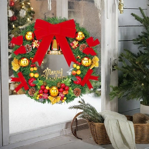 Detail view of a Christmas wreath with red bow and bells on a snowy window pane