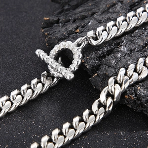 Detailed macro shot of silver Cuban link bracelet featuring a textured toggle OT clasp