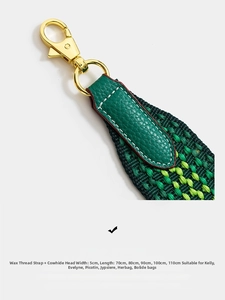 Detail of woven wide shoulder strap with green leather and gold metal carabiner hook