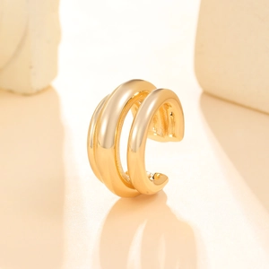 Macro shot of polished triple-layered gold ear cuff jewelry without piercings