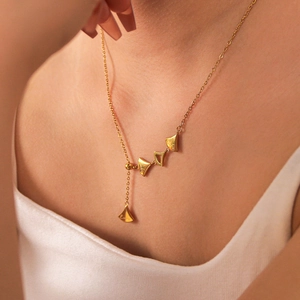 Golden stainless steel fan-shaped necklace with lucky engraving on a female model