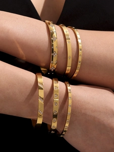 Detailed close-up of six gold-plated bangles featuring zircon clovers and star patterns