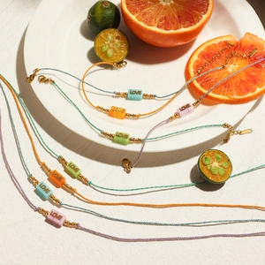 Colorful hand-woven Love bracelets with citrus fruits for a vibrant vacation style
