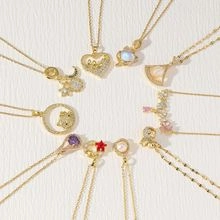 Detailed view of various gold-plated charms with colorful stones and pearl tassels