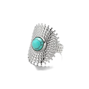 Detail of silver shield ring featuring a central turquoise stone and hammered texture