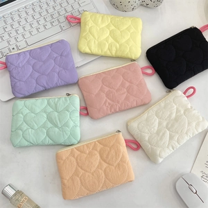 Flat lay of colorful quilted heart-shaped mini pouches in seven pastel macaron colors