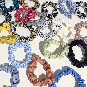 Colorful fabric scrunchies in various patterns like plaid, polka dots and leopard print