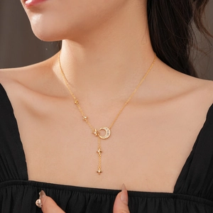 Detail of a gold-plated moon and star pendant necklace with cubic zirconia on a model