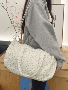 Dettaglio borsa da viaggio trapuntata a fiori con tracolla bianca e motivo floreale chic