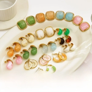 Detailed close-up of 18k gold plated titanium earrings with colorful resin textures