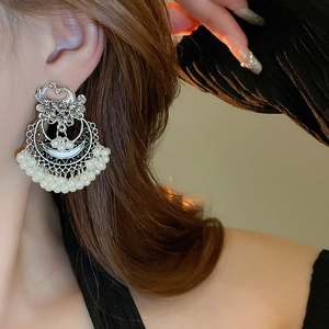 Detail of vintage silver boho earrings with pearls on model in natural light