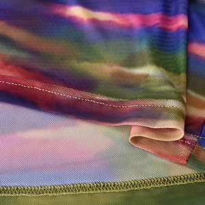 Detail aus buntem Mesh-Gewebe mit Farbverlauf, Atmungsaktivität und feiner Naht