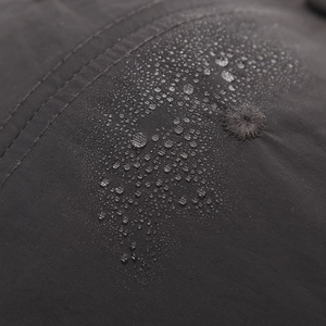 Waterproof dark grey baseball cap fabric detail with water droplets and breathable vents