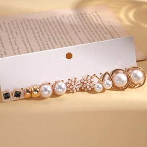 Detailed set of assorted pearl and gold finish earrings on white display card