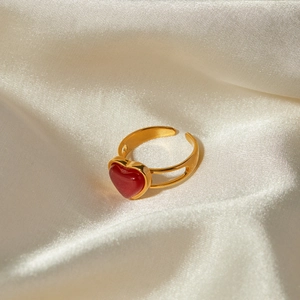 18k gold plated stainless steel open ring featuring a red agate heart on silk fabric