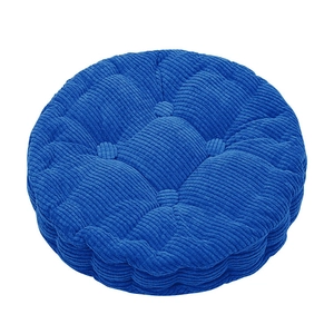 Detail of round navy blue corduroy chair pad with tufted design and soft texture