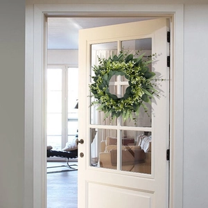 Couronne d'eucalyptus artificielle avec fleurs blanches sur porte blanche pour décor