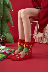 Vue détaillée de chaussettes de Noël rouges en polaire corail avec motifs festifs sur modèle