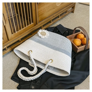 Detail of woven tote bag with white daisy flowers and gray-white color contrast