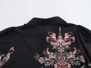 Close-up of ethnic print design and collar detail on back of a black long-sleeved shirt