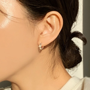 Close-up of elegant 925 sterling silver hoop earring with white pearl on model's ear